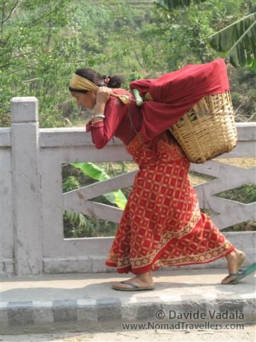 A woman carrying a wicker basket on the back as it is usual in Nepal. 