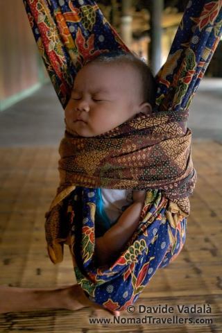A Dayak kid sleeping on a spring swinging cradle in Eheng longhouse