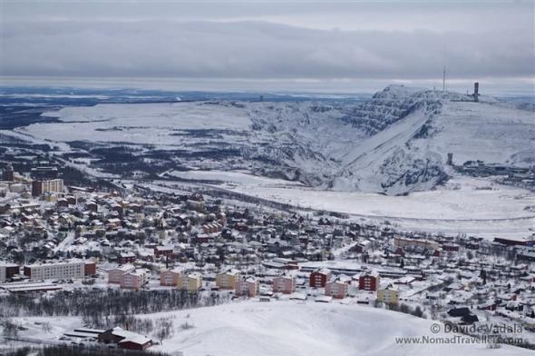 View of Kiruna from the old mine on Luossavaara hill. The center of the city, visible in the picture, will be relocated because of the extension of the new mine, visible in the background where a huge hole and Kiirunavaara hill are located. 1 Kiruna-iron-ore-mine7075